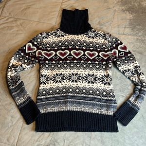 Knitted High Neck Sweater with an ornament.